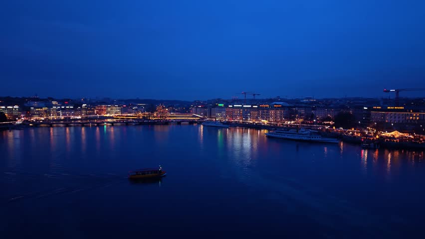 Aerial view of boats sailing on Lake Geneva in La Rade reflecting city lights, a tranquil scene with the city skyline, Geneva, Geneva, Switzerland.