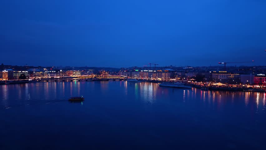 Aerial view of a boat sailing on Lake Geneva in La Rade, with lights reflecting on the water creating a beautiful scene, Geneva, Geneva, Switzerland.