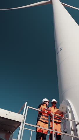 Two engineer working at a wind turbine power generation site.