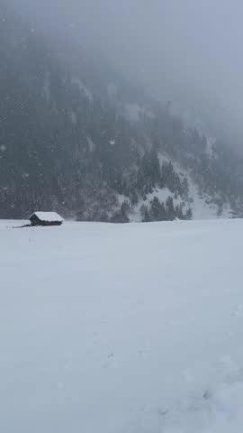 Raw Documentary Style View of Isolated Winter Hut in the Distance in heavy snow