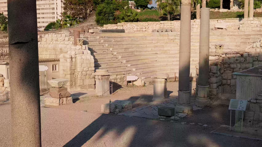 Panning footage showing ancient stone amphitheater ruins with preserved seating tiers and columns. Roman amphitheatre in Alexandria, Egypt