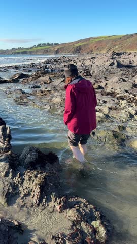 Woman taking her first steps in the sea with smiles and laughter. 