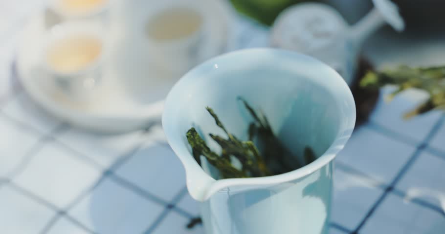 Pouring hot water from a ceramic teapot to brew tea. Traditional charcoal stove in winter. Authentic daily life scene shot in real-time speed. High quality DCI 4K footage.