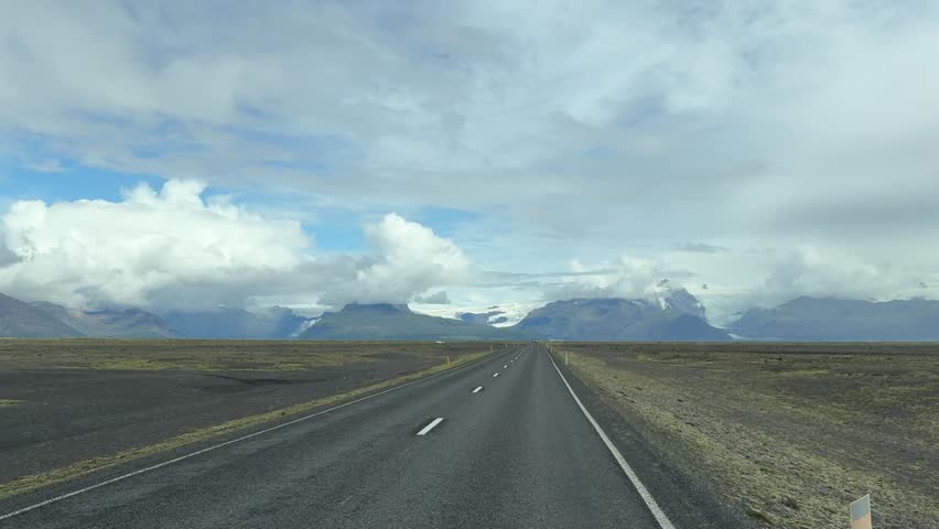 Lonely Road Stretching Toward Distant Mountains in Iceland. High quality FullHD footage