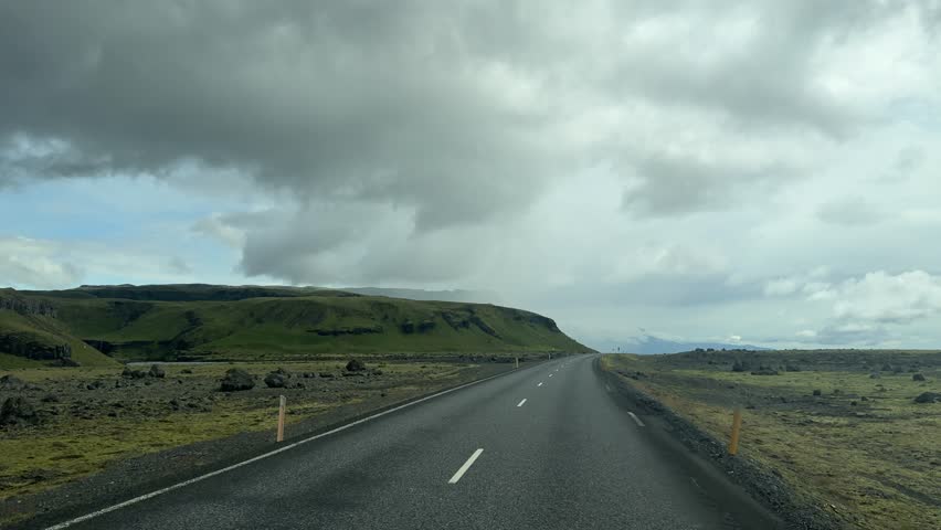 Winding Road Through Remote Green Highlands under Heavy Clouds in Iceland. High quality 4k footage