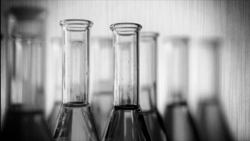 A set of glass test tubes filled with different colored liquids.. Retro video.