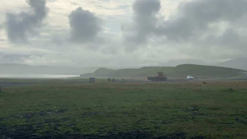 Expansive Green Meadow under Dramatic Cloudy Sky in Iceland. High quality 4k footage