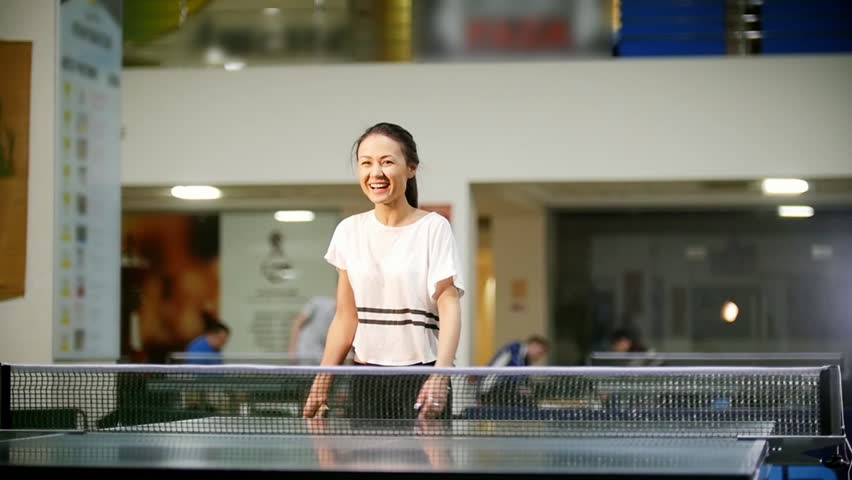 Ping pong playing. Young smiling woman playing table tennis