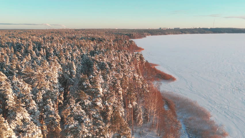 Drone Flight Over Frozen Forest Lake With Pine Trees and Hunting Lodge