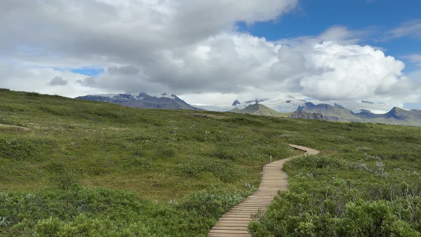 Long Boardwalk Trail Across Expansive Green Plain in Iceland. High quality 4k footage