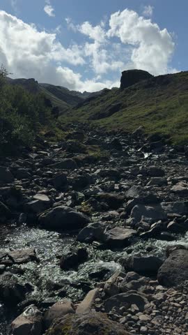 Barren Rocky Terrain with Distant Green Hills under Cloudy Sky in Iceland. High quality 4k footage