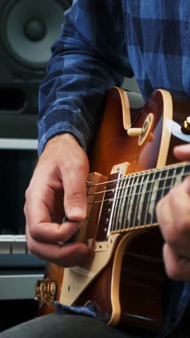 Guitar player playing chords on electric guitar at home, close up of guitar and hands. Vertical video