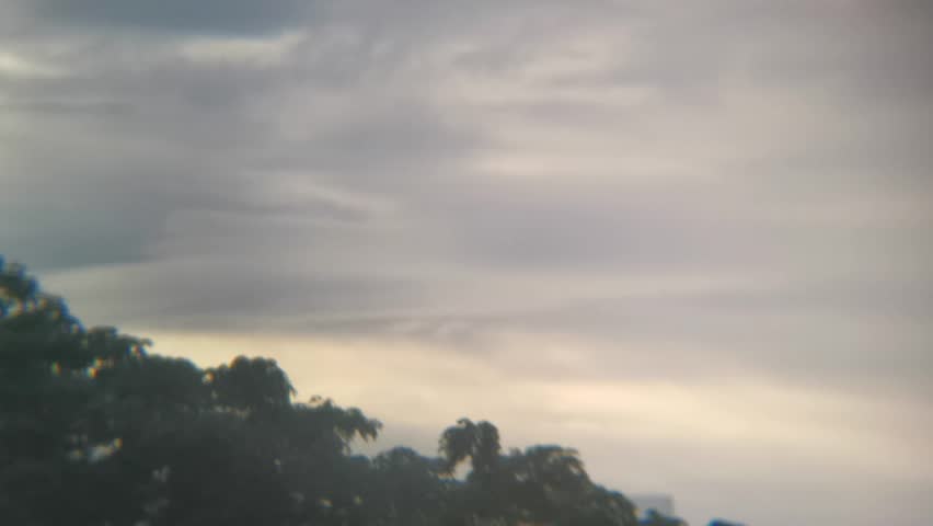 A view of thick clouds over the city skyline, captured using a mobile phone monocular telephoto lens accessory
