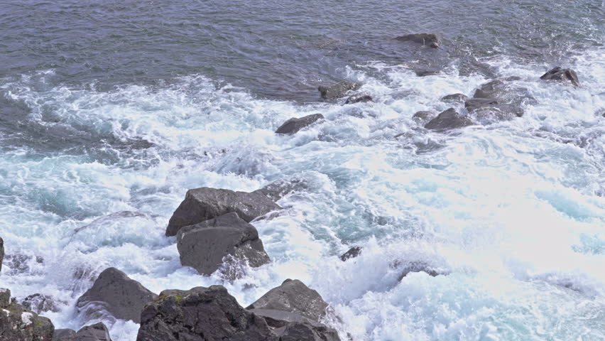 Exploring rapid river water flowing through rocks in Thingvellir in Iceland