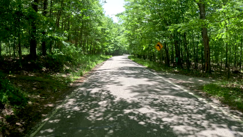 Tunnel of Trees Scenic M-119 Byway in Northern Michigan, USA. Road trip through the Tunnel of Trees M-119 Scenic Byway in Northern Michigan, USA. M-119 in Michigan refers to the scenic Tunnel of Trees, a 20-mile stretch of narrow, winding highway (also known as the M-119 Heritage Route) along the Lake Michigan shoreline in Emmet County, famous for its dense hardwood canopy and panoramic lake views between Harbor Springs and Cross Village.