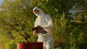 Young environment inspector in biohazard suit assessing current pollution levels, collecting samples, and documenting data near a toxic barrel outdoors, slow motion shot - Powered by Shutterstock - Get 15% off with code: PIKWIZARD15