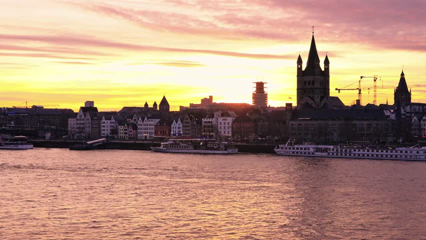 View from the Deutz side of the Rhine, looking toward the Old Town. The skyline is dominated by the Great St. Martin Church and the silhouette of the Cologne Cathedral.