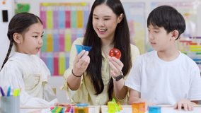 Smiling teacher teaches two children geometric shapes with colorful learning materials in bright classroom - Powered by Shutterstock - Get 15% off with code: PIKWIZARD15