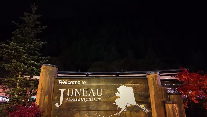 Gimbal close booming down shot of the "Welcome to Juneau" signage at night in Southeast Alaska. 4K