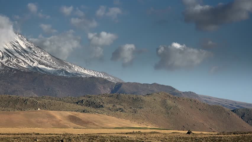 Snowy volcano cone with pyramid peak of Mount Hasan in Aksaray Turkey Central Anatolia. High altitude volcanic mountain covered in white snow creating majestic landscape.