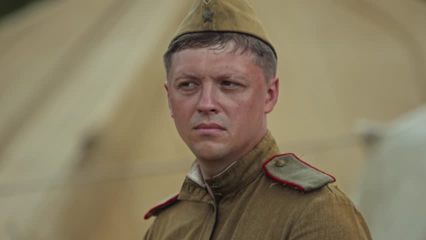 Red Army private soldier portrait, authentic uniform, pilotka side cap. Serious facial expression, Great Patriotic War reenactment, outdoor camp.