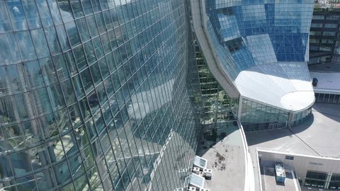 Drone Moving Past Curved Glass Office Building