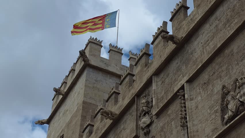 low angle view of the lonja de la Seda ( Silk Exchange ) with the Flag of the Valencia Community flying above , a UNESCO world heritage site and a masterpiece of late Gothic architecture. Valencia, Spain 