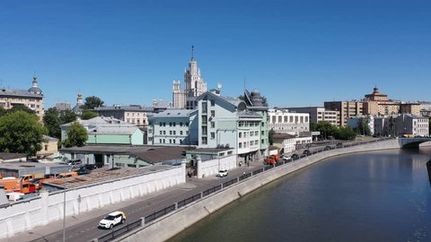 Drone Ascent Along Embankment with Stalinist Skyscraper View