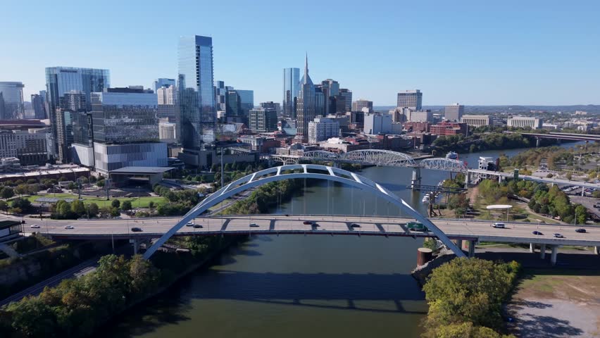 Aerial over Korean Veterans Memorial Bridge in downtown Nashville, TN on a blue daytime sky and the city skyline