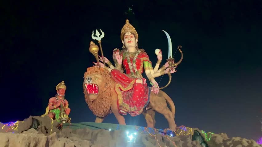 Goddess Durga with Hanuman seated on a lion, representing feminine power, victory over evil, courage, and divine motherhood, beautifully illuminated for religious worship and festival celebration.