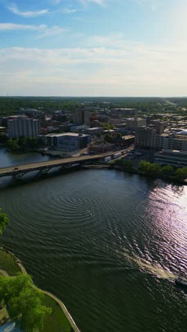 An aerial shot captures the vibrant cityscape of Rockford, Illinois, with the scenic Rock River winding through it.