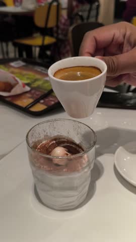 Pouring Hot Espresso Coffee over White Cream Dessert in Glass