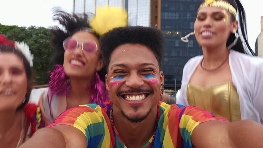 Group of friends joyfully capturing a selfie at Brazilian Carnival street festivities. Smiling faces in colorful costumes celebrating together in vibrant festival energy