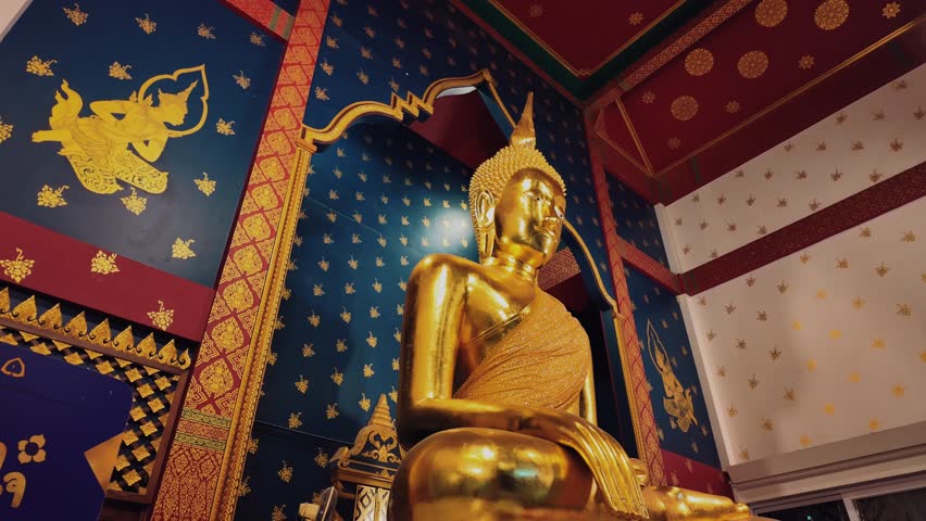 Golden Buddha statue inside Wat Saket temple with ornate interior, Lit gold Buddhism shrine with blue wall decoration in Thai temple in Bangkok 4k