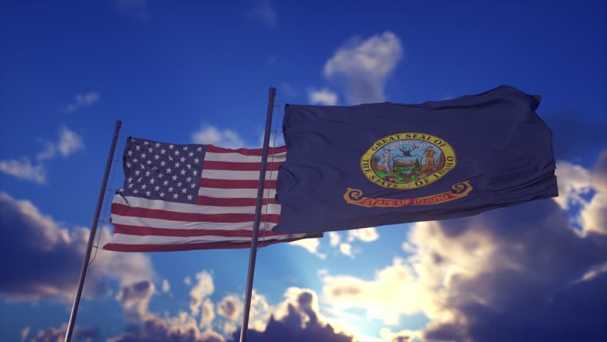 Flags of the United States and Idaho Waving Against Dramatic Sky at Sunset