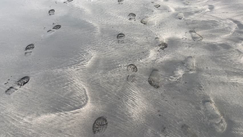 Camera following footprints in the sand