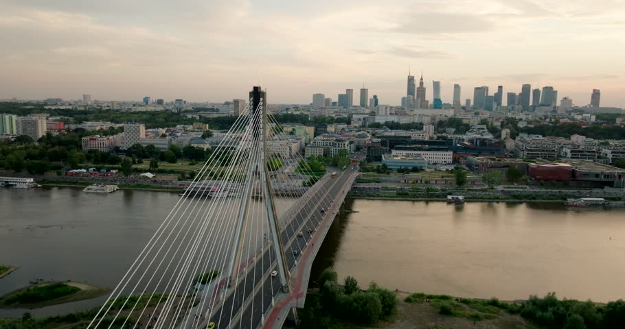 Warsaw skyline with Suspension Bridge. Poland Capital Cityscape at golden hour with landmarks, urban districts and skyscrapers. Ideal for travel and city establishing footage. Wide 4K drone shot