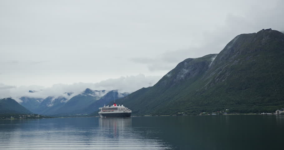 Cruise ship sailing through a norwegian fjord with mountains