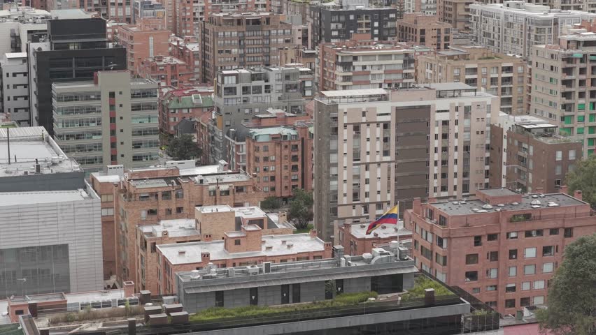 Wide aerial shot of Bogotá’s urban environment, capturing repetitive brick buildings and the structured layout of the city.