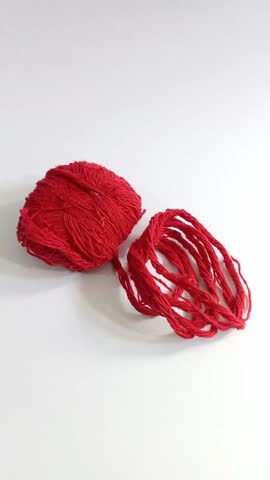 Red Yarn 
A ball of bright red yarn displayed on a white background. It is soft fine thread used for knitting, crocheting, or weaving crafts The yarn is versatile for making