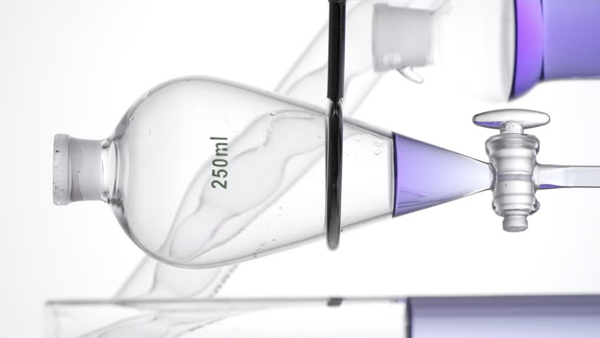 A chemistry setup with ball absorber bottle, bubble condenser, and separatory funnel as transparent violet liquid is injected, making waves on neutral white surface | Butterfly pea flower tincture