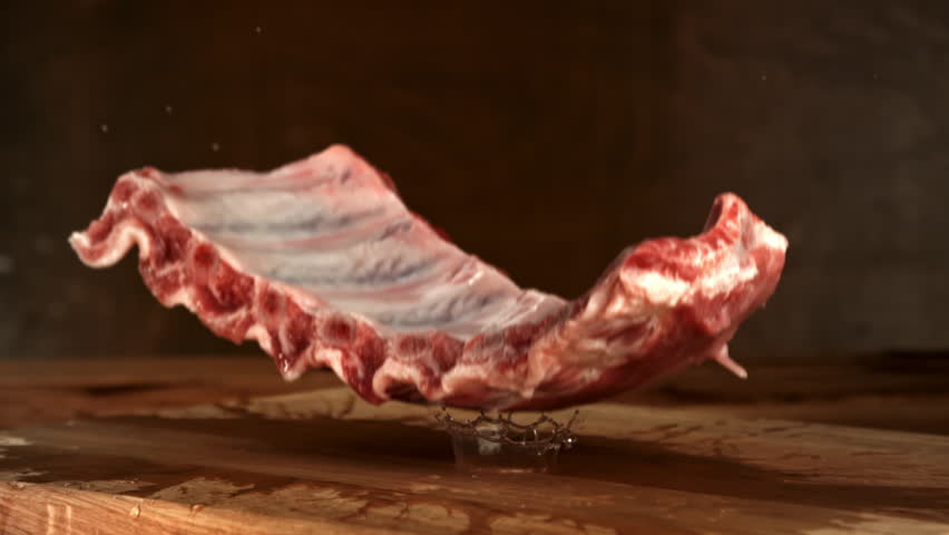 Raw pork ribs fall onto a cutting board. Filmed on a high-speed camera at 1000 fps. High quality FullHD footage