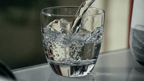 soda water pouring to glass cubes. poured water glass. bubbles water cup close-up. pours mineral water slow motion. summer cool ice drink on - Powered by Shutterstock - Get 15% off with code: PIKWIZARD15