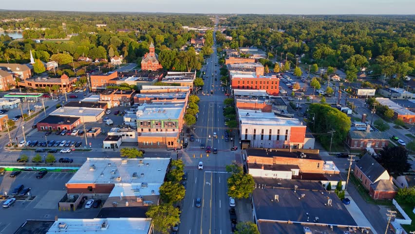 Drone view above Grand River Ave in Howell, Michigan, USA with Livingston County Courthouse at sunset, aerial view