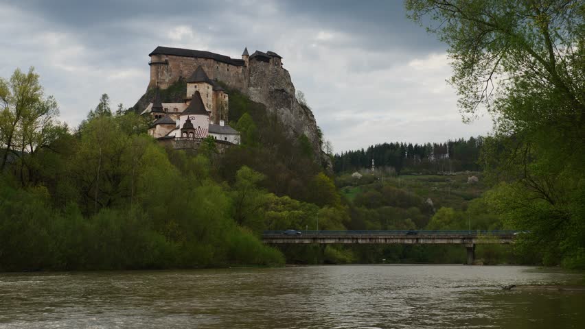 Vehicles crossing the bridge over the Orava river and under the castle, Slovakia
