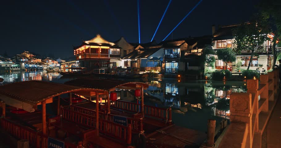 Zhujiajiao, Shanghai, China. traditional architecture illuminated with festive lights during the night, enhancing the lively atmosphere around the waterways and buildings. time lapse