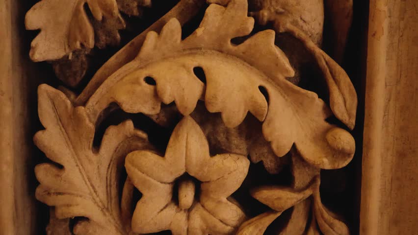 Upward moving closeup of detailed pattern and figures carved out of stone. Decorative carvings with leaves, flowers and exotic birds motifs on an ornate interior wall at Monserrate Palace in Sintra