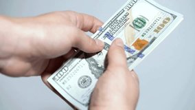 Human hands converting hundred dollar bills manually at white background, closeup view. Fingers quickly counting a stack of dollar bills on a white background. hands counting a bundle of dollars. - Powered by Shutterstock - Get 15% off with code: PIKWIZARD15