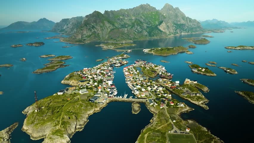 Aerial droneview of Reine, A remote Arctic village framed by towering peaks and deep fjords, captured from above in the heart of the Lofoten Islands.