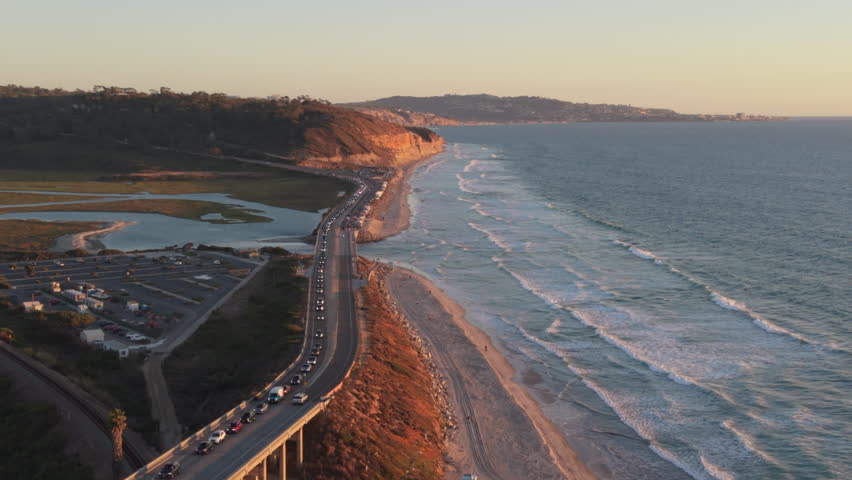 Traffic is backing up at Torrey Pines State Beach in Del Mar, California. San Diego beach at sunset, drone view.